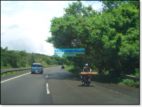 Dominican Republic picture- Moto Driver takes to highway with a five foot long box